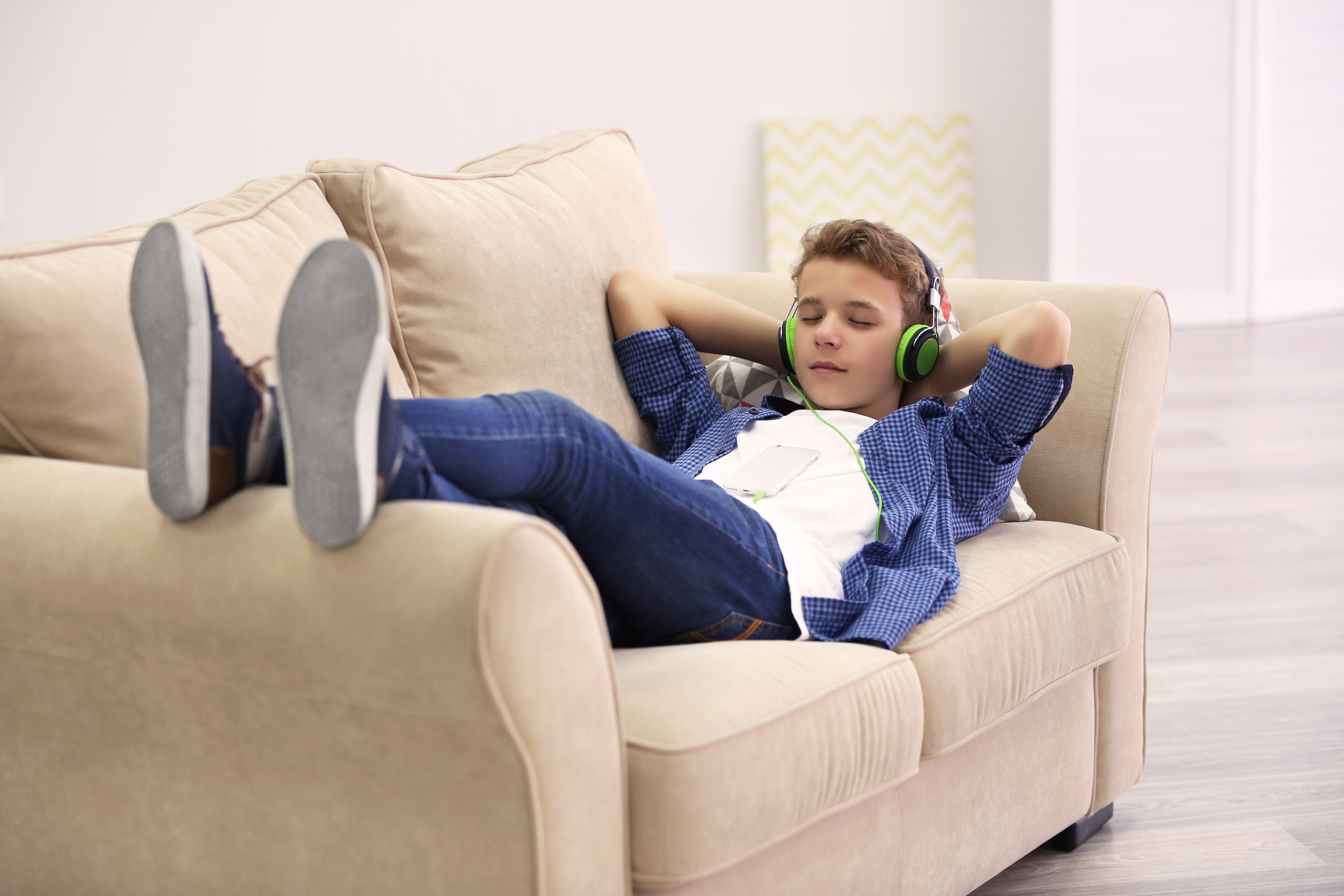 Boy listening music on sofa