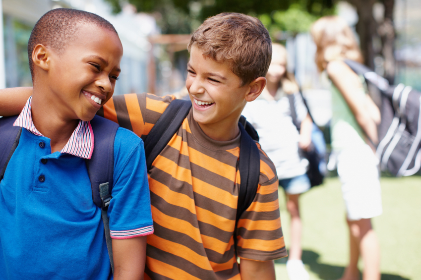 Two boys in their school playground having a good laugh together - copyspace